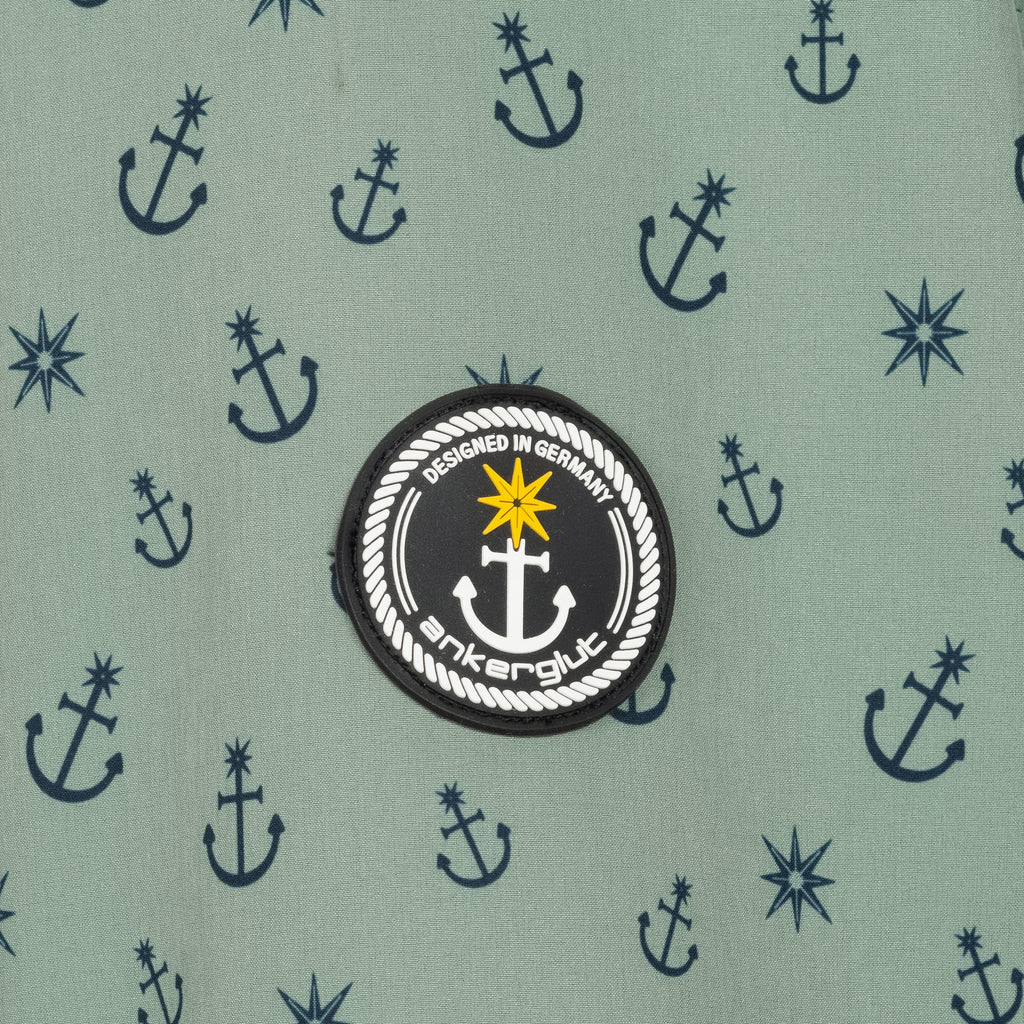 Ankerglut Softshelljacke Ankerglutschein in Grau, Detailansicht Stoff mit Ankerdruck und Logo-Patch